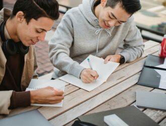 Image of two students preparing a thesis statement for an essay